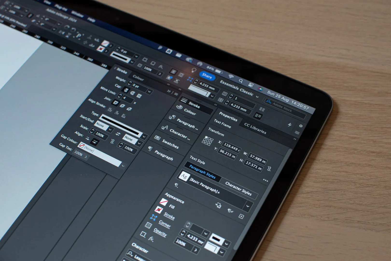 A close-up of a designer's workstation showing a website design tool open on a laptop screen.