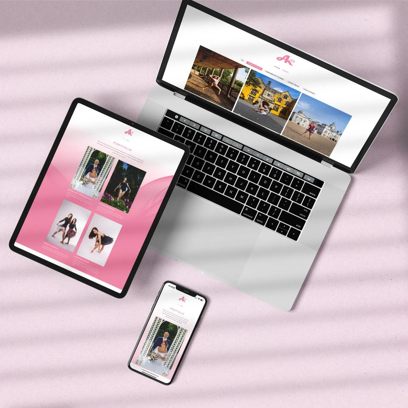 Amber Kelly Photography. A laptop, tablet, and smartphone display a website featuring a portfolio of photos, likely showcasing a photographer's work. The website's design is predominantly pink and white, with a black border around the devices. The background of the